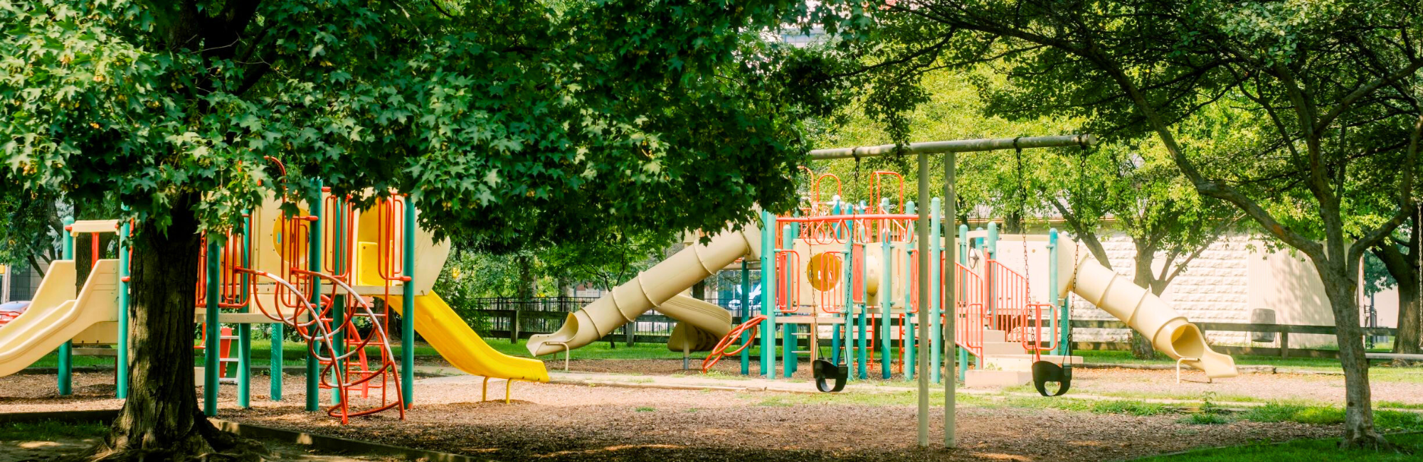 Park with tree coverage and a playground