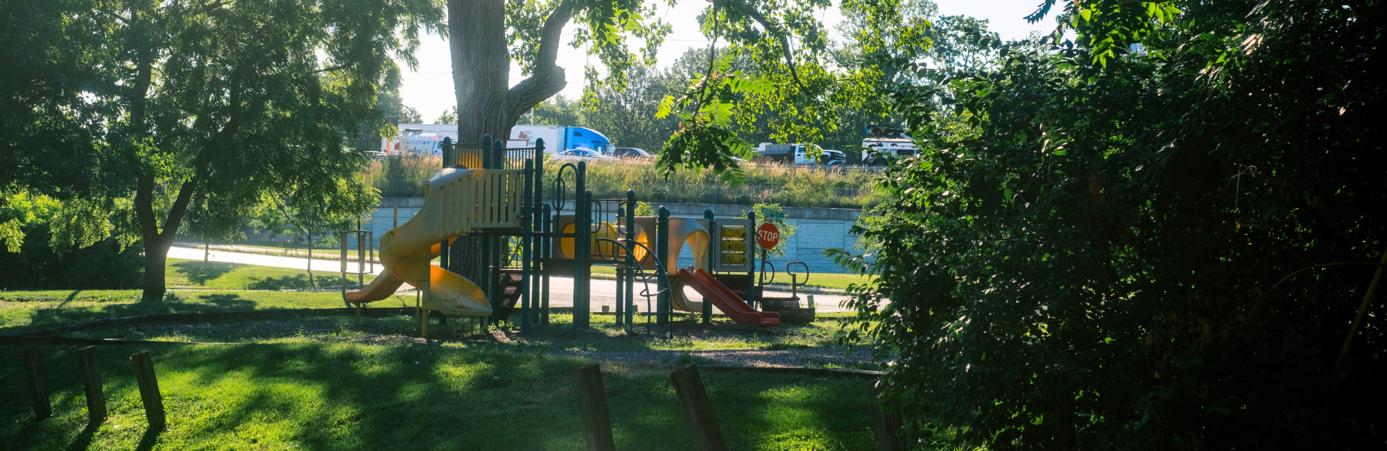 park in a shaded area with trees surrounding a playground